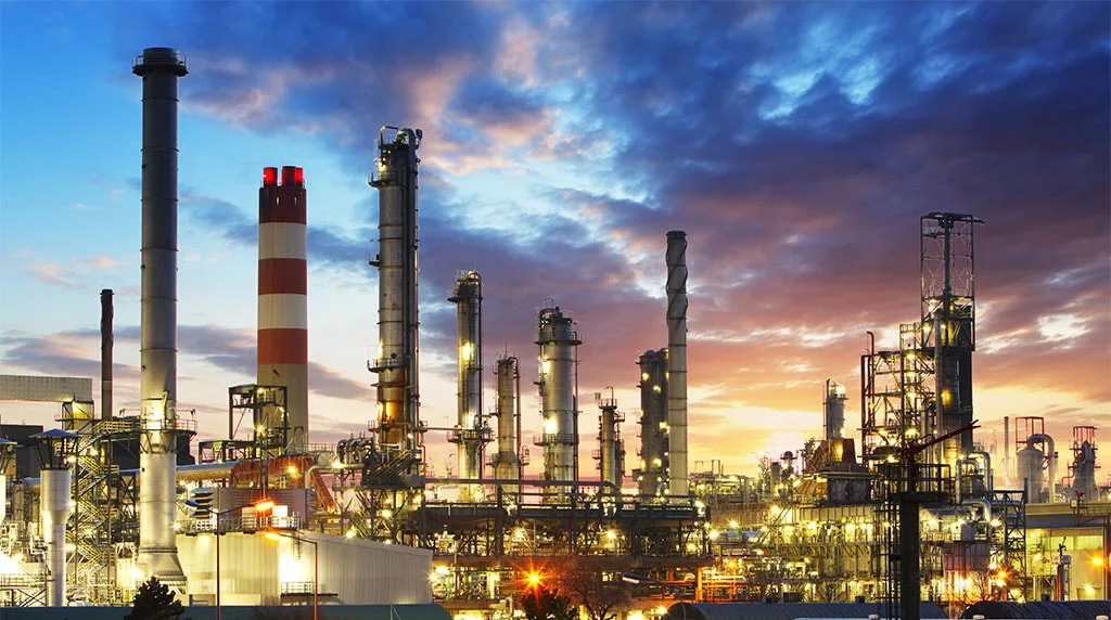 An industrial refinery and power complex illuminated at dusk
